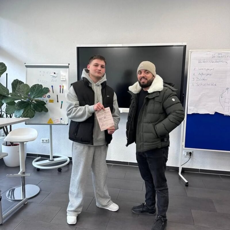Candidat heureux après une réussite dans son parcours vers le permis de conduire, accompagné par son formateur pour obtenir son permis plus rapidement.